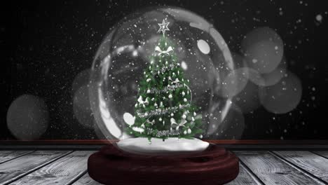Digital-animation-of-shooting-star-spinning-around-christmas-tree-in-snow-globe-on-wooden-surface