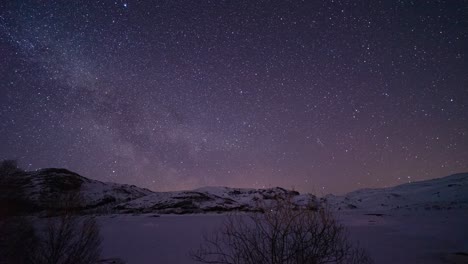 timelapse of the milkeyway over a frozen lake and snow in norway