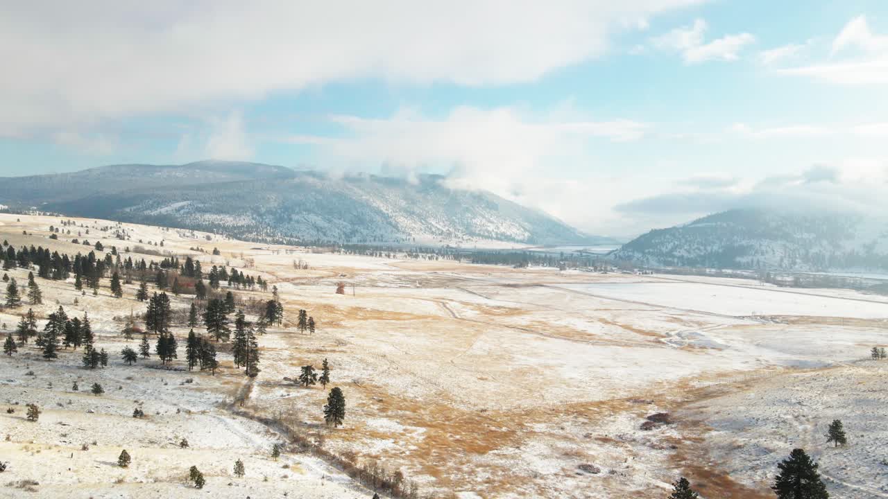 plano general de los pastizales del valle de nicola cubiertos de nieve ligera en un día parcialmente nublado en invierno con sol en merritt, bc canadá