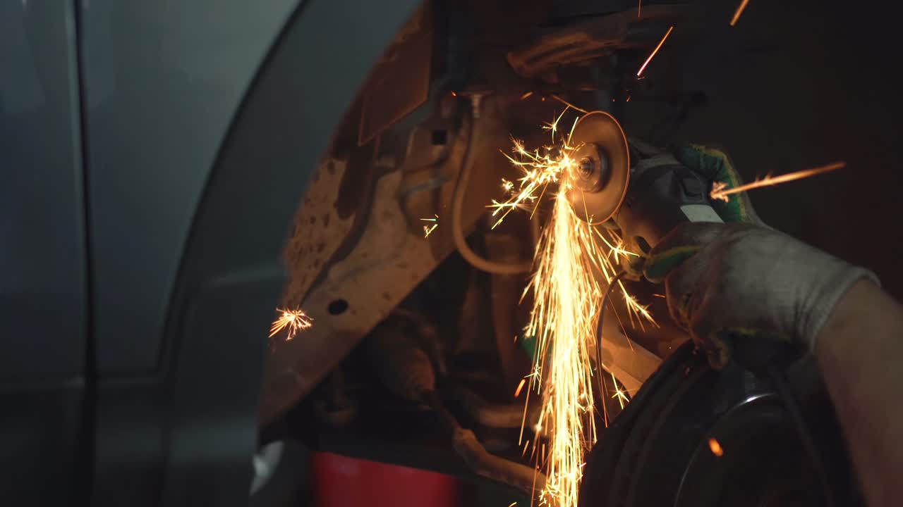 노동자 는 자동차 서비스 스테이션 의 스티어링 랙 에서 녹말 한 볼트 를 절단 합니다.