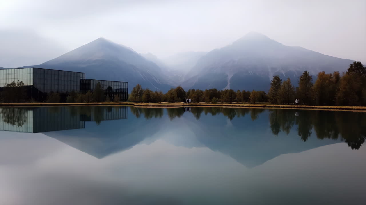 Serene Lake Reflecting Misty Mountains and Modern Architecture in Autumn