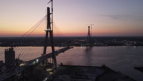 Gordie-Howe-International-Bridge-under-construction,-between-USA-and-Canada,-over-the-Detroit-River-during-sunset