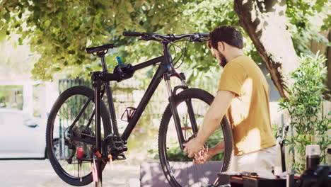 Man-removing-damaged-bicycle-wheel