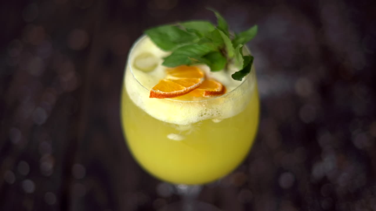 Et glas gul lemonade med mynte på en træoverflade