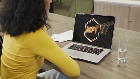 video de una mujer afroamericana trabajando en una computadora portátil con nft en la pantalla