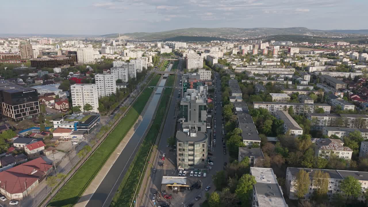 Вид с дрона на реку Бахлуй возле Подул-де-Пятра в Яссах с канализированной рекой, дорогами и жилыми зданиями при дневном свете.