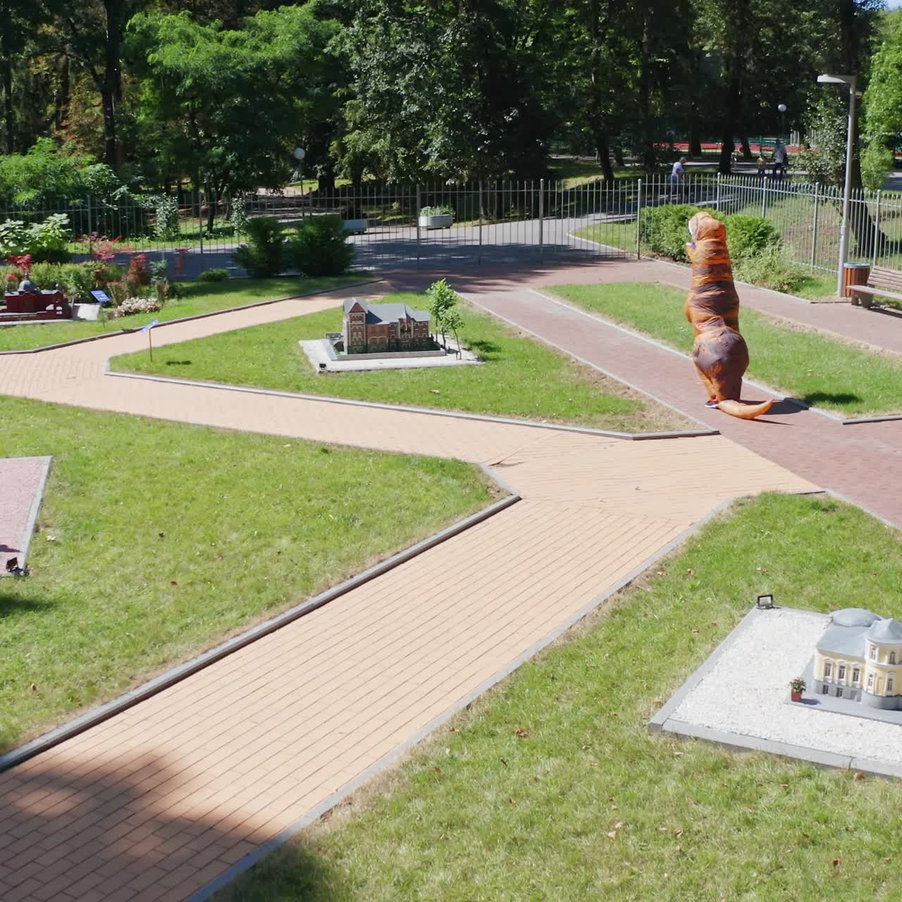 Carnival dragon suit walking in the city park. Funny attractive blow-up dragon