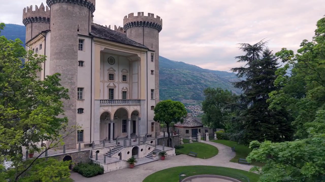 Storico Castello di Aymavilles con le sue torri e loggia uniche al crepuscolo in Valle d'Aosta, Italia. Ripresa aerea in avanti.