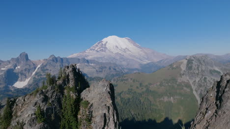 imágenes aéreas que vuelan hacia atrás a través de las crestas rocosas de las montañas cascade con el monte rainier en el fondo