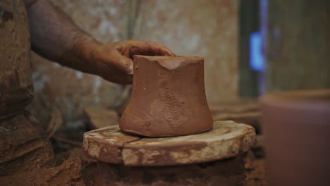 potter preparing clay for shaping on a potter's wheel