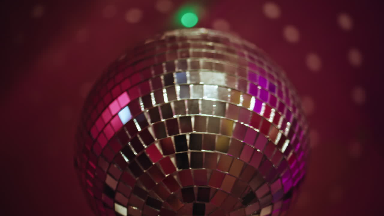 Closeup disco ball hanging at night party. Mirrored sphere reflecting nightclub