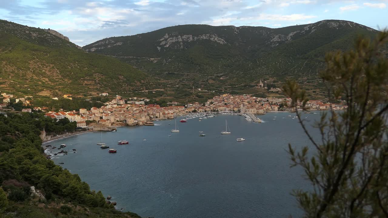 Komiza, Isola di Vis, Croazia, centro storico tra montagne e mare, ripresa in ascesa