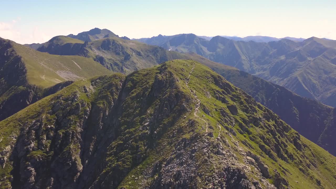 vista aérea ascendente del pico de la montaña verde y sendero estrecho que conduce a la cumbre