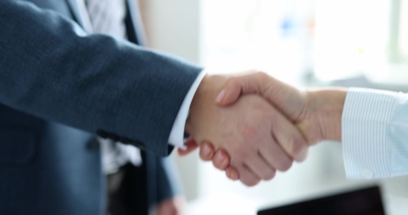 Primo piano di stretta di mano tra partner commerciali in ufficio, video 4K al rallentatore