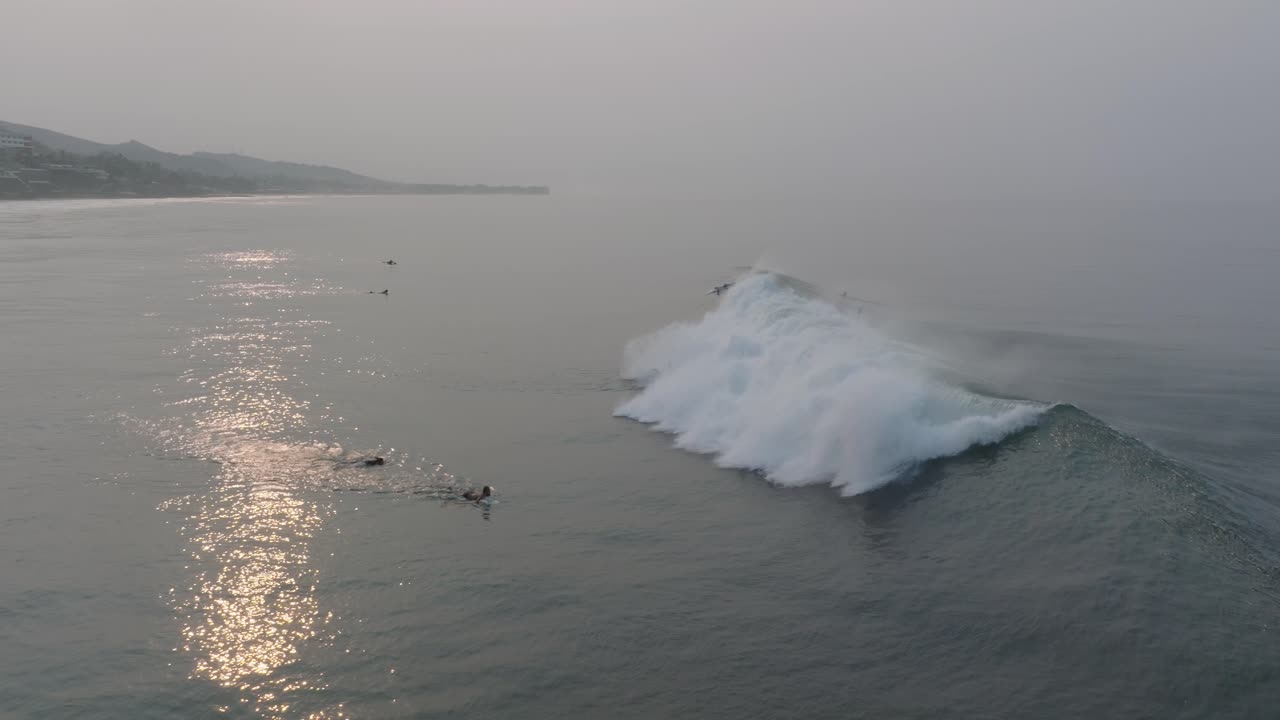 해가 뜨는 순간 에 서퍼 들 이 서서히 움직이는 드론 의 모습 라 보카나 엘  ⁇ 코 엘 살바도르
