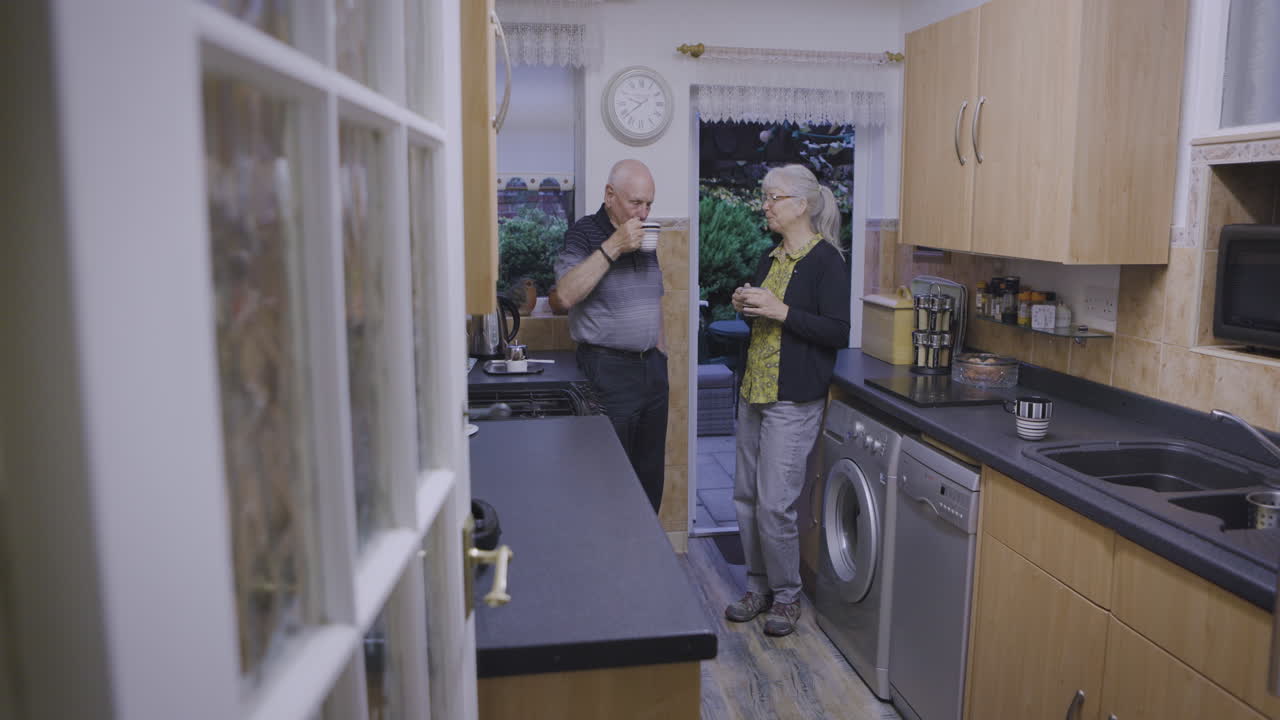 Coppia anziana che conversa in cucina