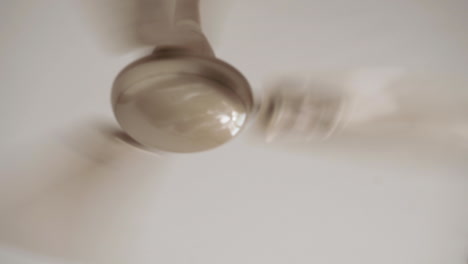 close up of a ceiling fan rotating on high speed on a summer day in india