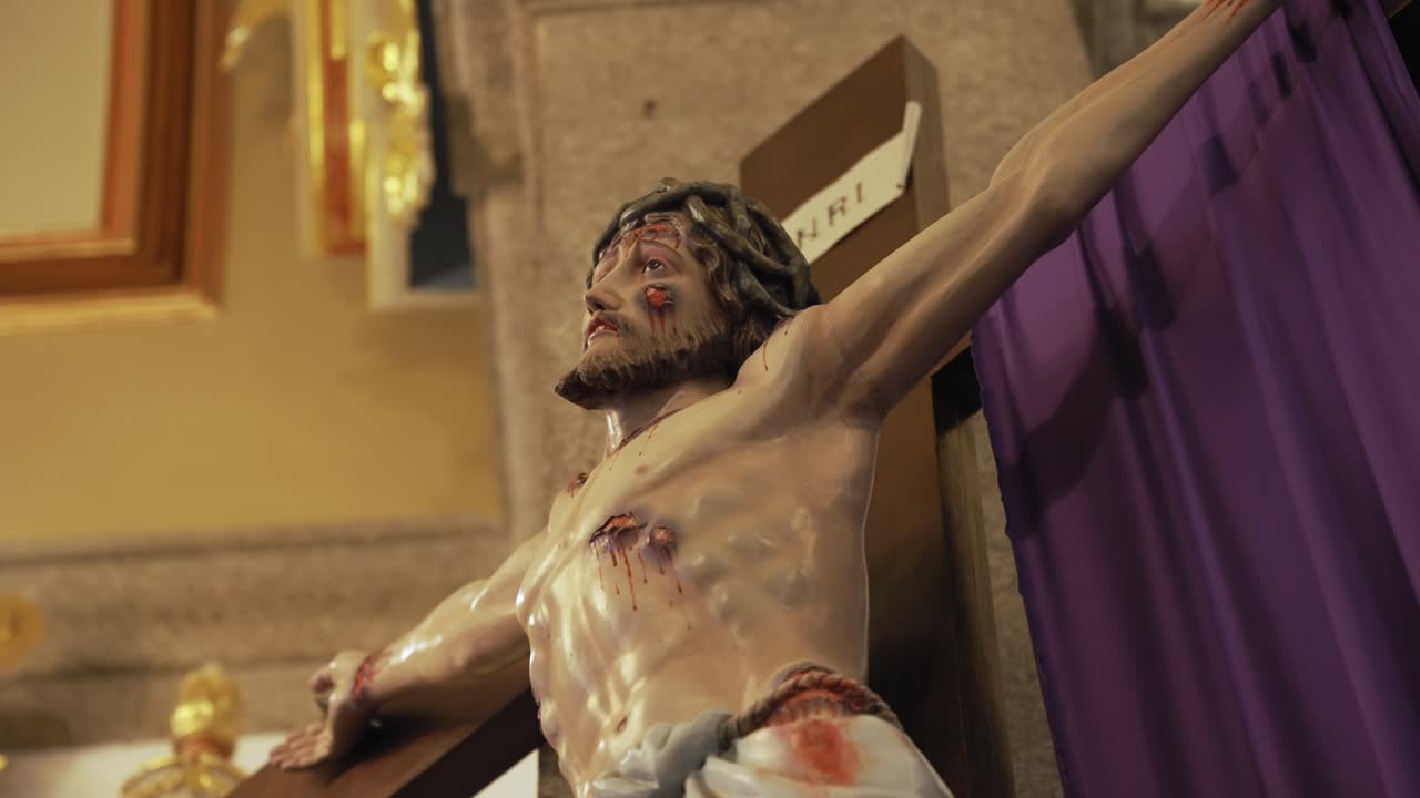 Primo piano dettagliato di scultura religiosa di Gesù Cristo crocifisso in chiesa.