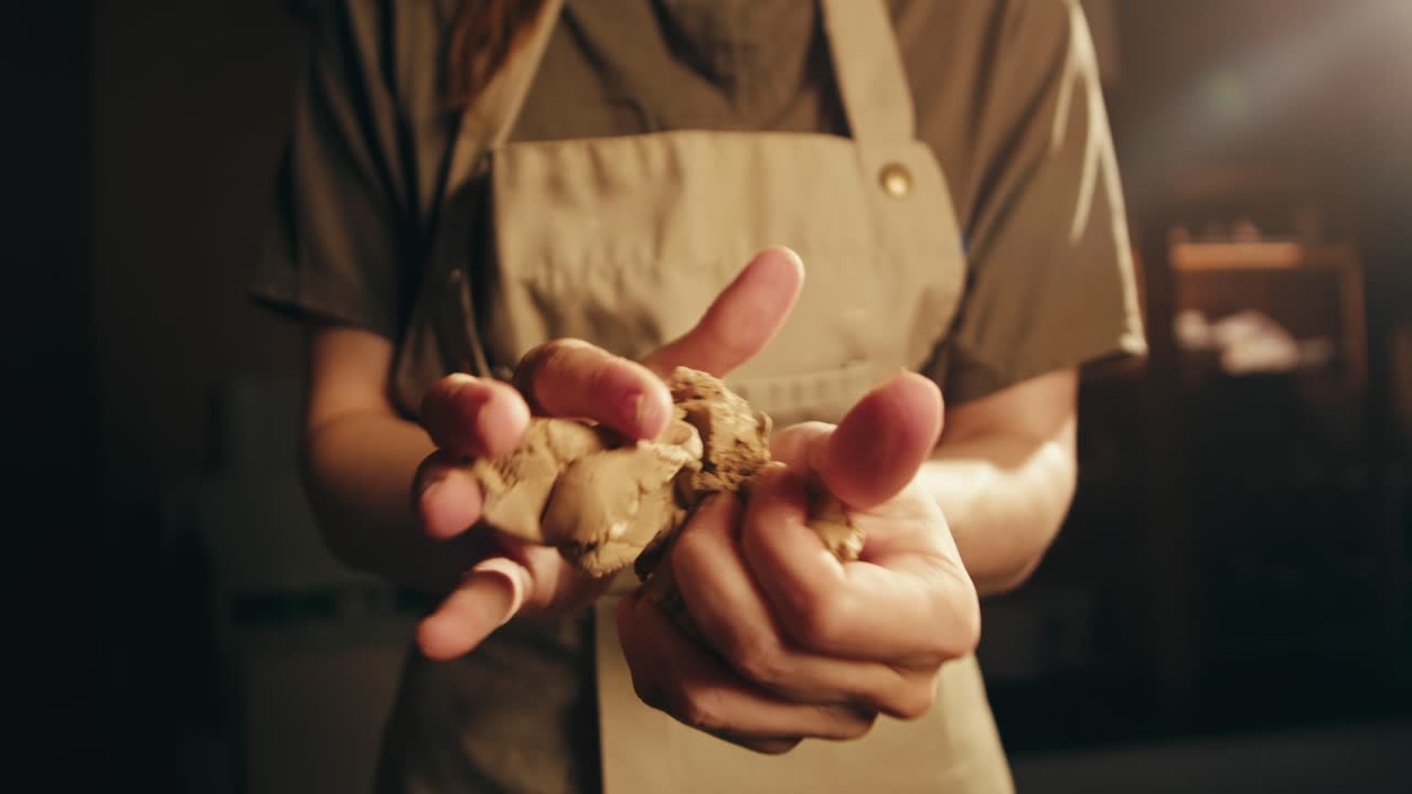 mujer amassando arcilla