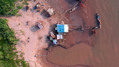 Bird-eye-aerial-drone-footage-flying-over-a-fisherman-house-on-the-Mekong-shore-near-Phnom-Penh-in-Cambodia