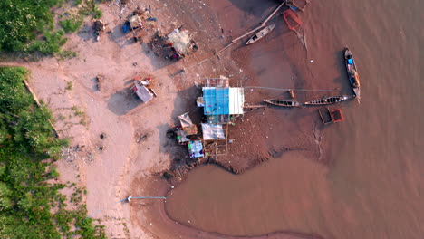 imágenes de drones aéreos de ojo de pájaro volando sobre una casa de pescadores en la costa del mekong cerca de phnom penh en camboya