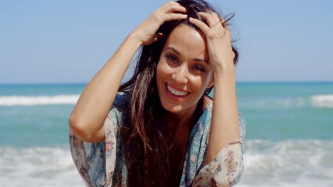 Mujer-Feliz-En-La-Playa-Mirando-A-La-Cámara