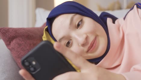 muslim girl looking at her smartphone.