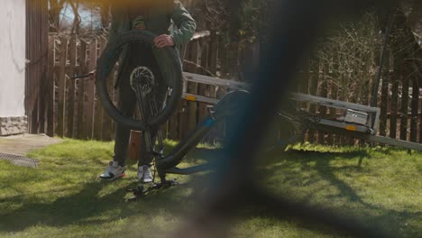 man repairing his mountain bike in the garden