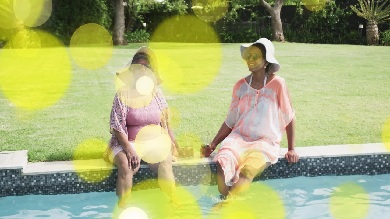 Relaxando à beira da piscina, mulheres com animação de luz bokeh amarela ao fundo