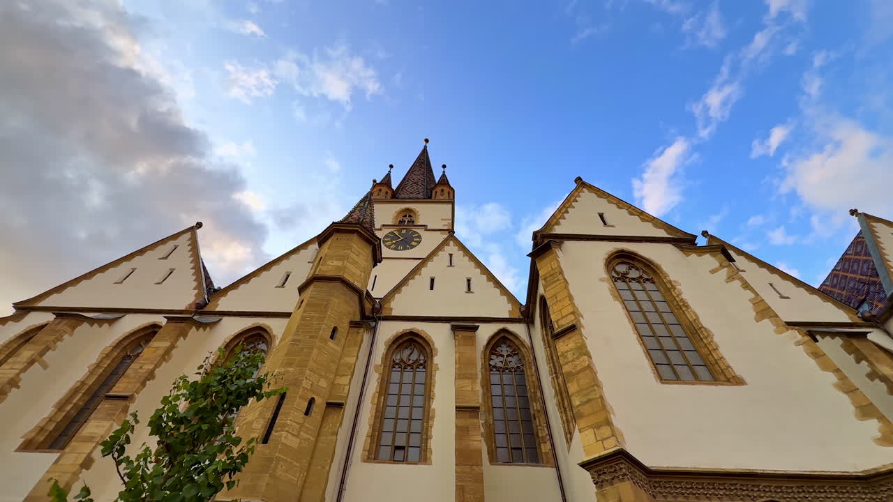 Gothic architecture of Sibiu Cathedral close-up. Close-up upward view of the Evangelical Cathedral tower in Sibiu, Romania against a blue sky