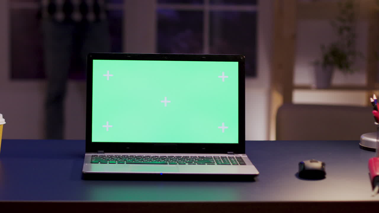 portátil con pantalla verde en el escritorio