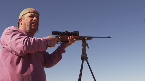 un hombre usa un rifle de cerrojo para practicar tiro al blanco antes de cazar ciervos en el rango de colorado