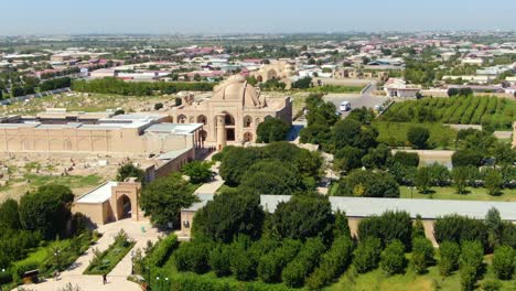 tourists at baha-ud-din naqshband bokhari memorial complex with green trees on garden in bukhara, uzbekistan