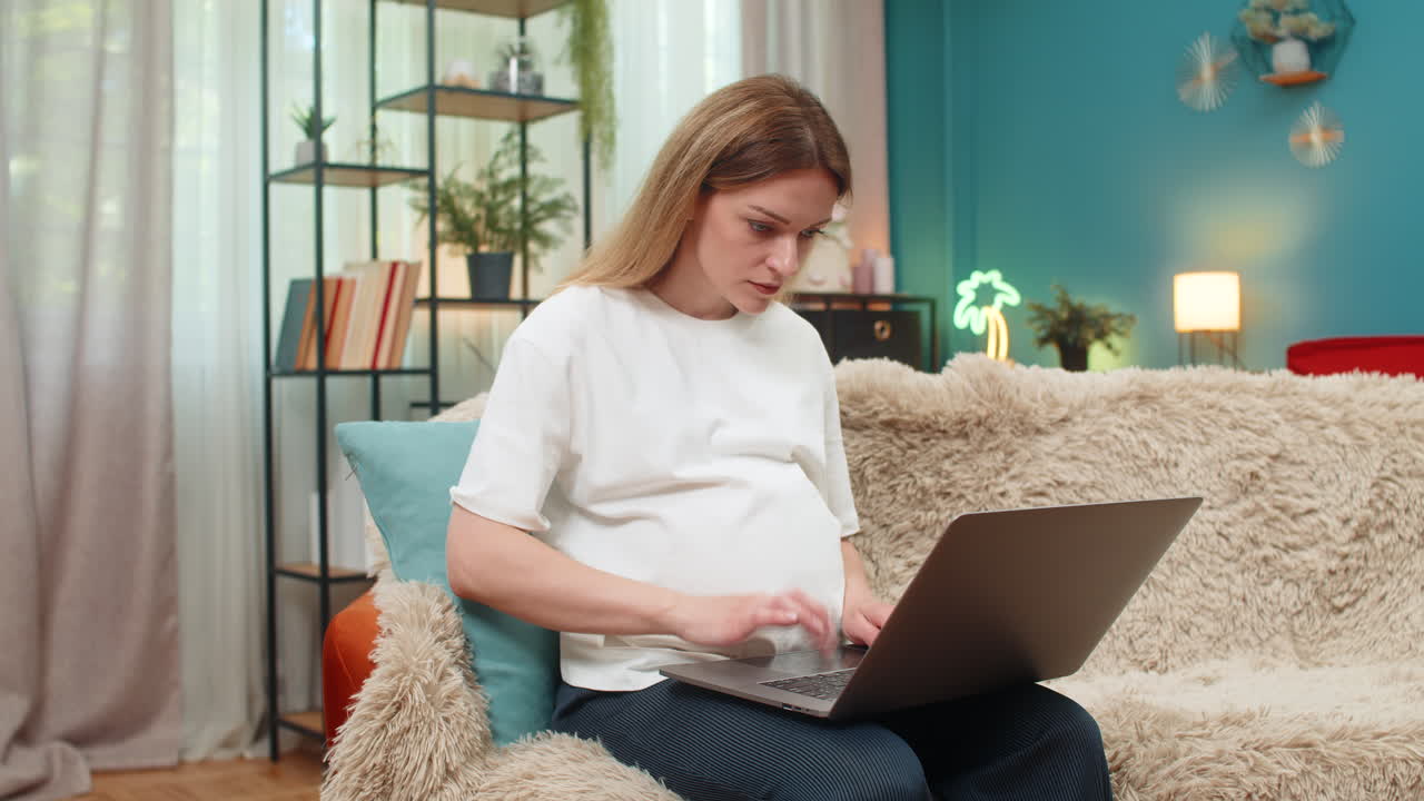 Pregnant woman frustrated as laptop freezes waves hand moves device aside upset working at home sofa