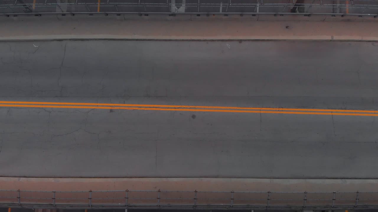 Top down aerial view of highway below bridge, above overpass towards other side of expressway, aerial approach