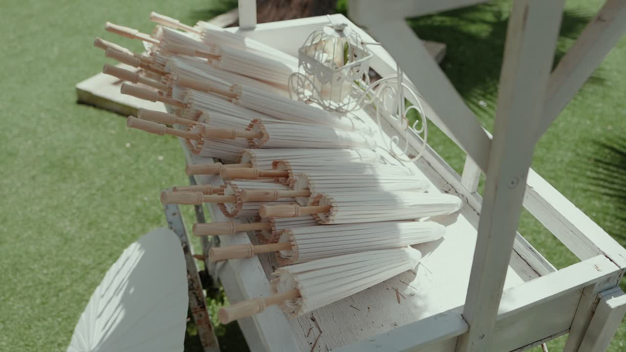 folded paper umbrellas arranged neatly on decorative white cart outdoors
