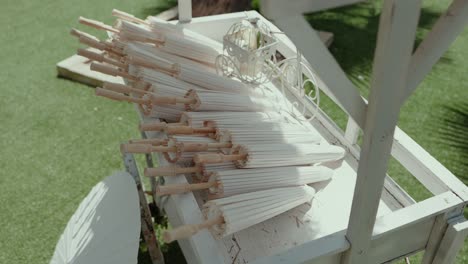 folded paper umbrellas arranged neatly on decorative white cart outdoors