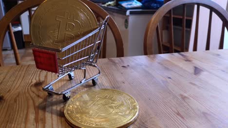 golden bitcoin crypto currency coins in tiny shopping trolley on kitchen table concept rotating left shot