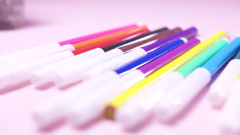 colorful markers on pink background