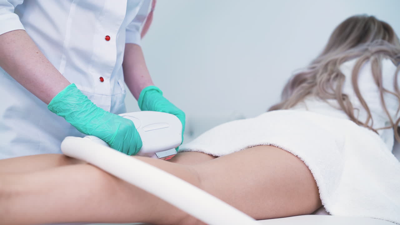 el dermatólogo usa equipos para hacer la depilación con láser a la niña.