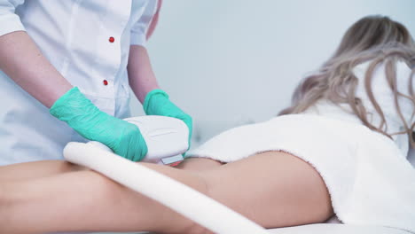 el dermatólogo usa equipos para hacer la depilación con láser a la niña.