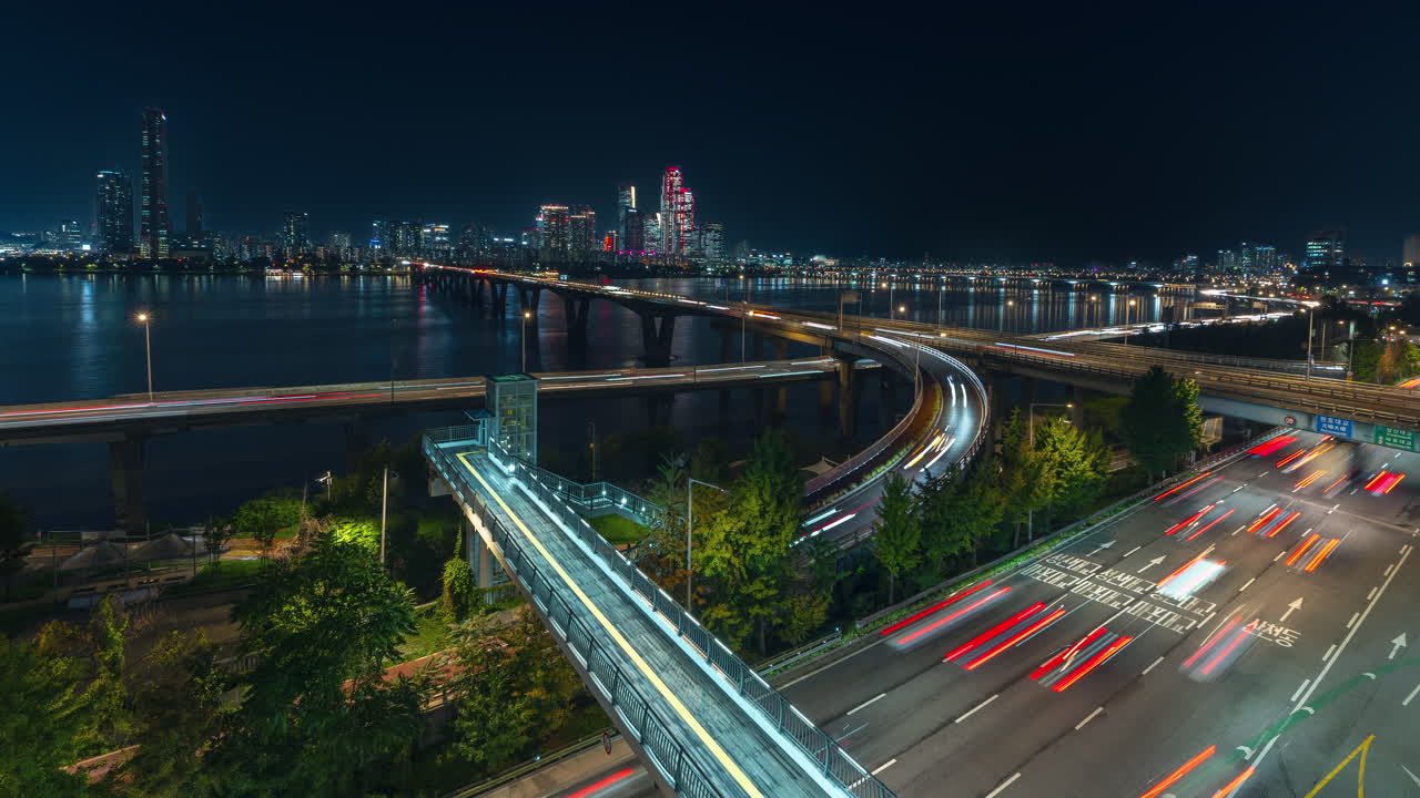 Busy Seoul Night Cars Traffic on Gangbyeongbuk-ro Expressway and Wonhyo Bridge, Many Cars Driving Riverside Han River in City Downtown Illuminated Yeouido Skyscraper Buildings in Backdrop -Time Lapse