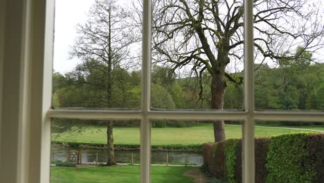 SLIDER-PAN-RIGHT-looking-out-through-window-frame-into-garden-lawn-and-River-Wye-running-through-it