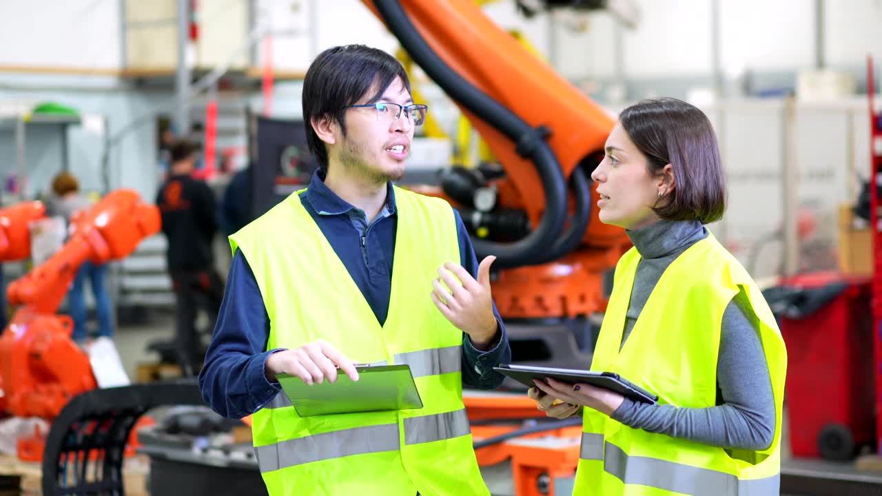 Engineers discussing a robot in a factory