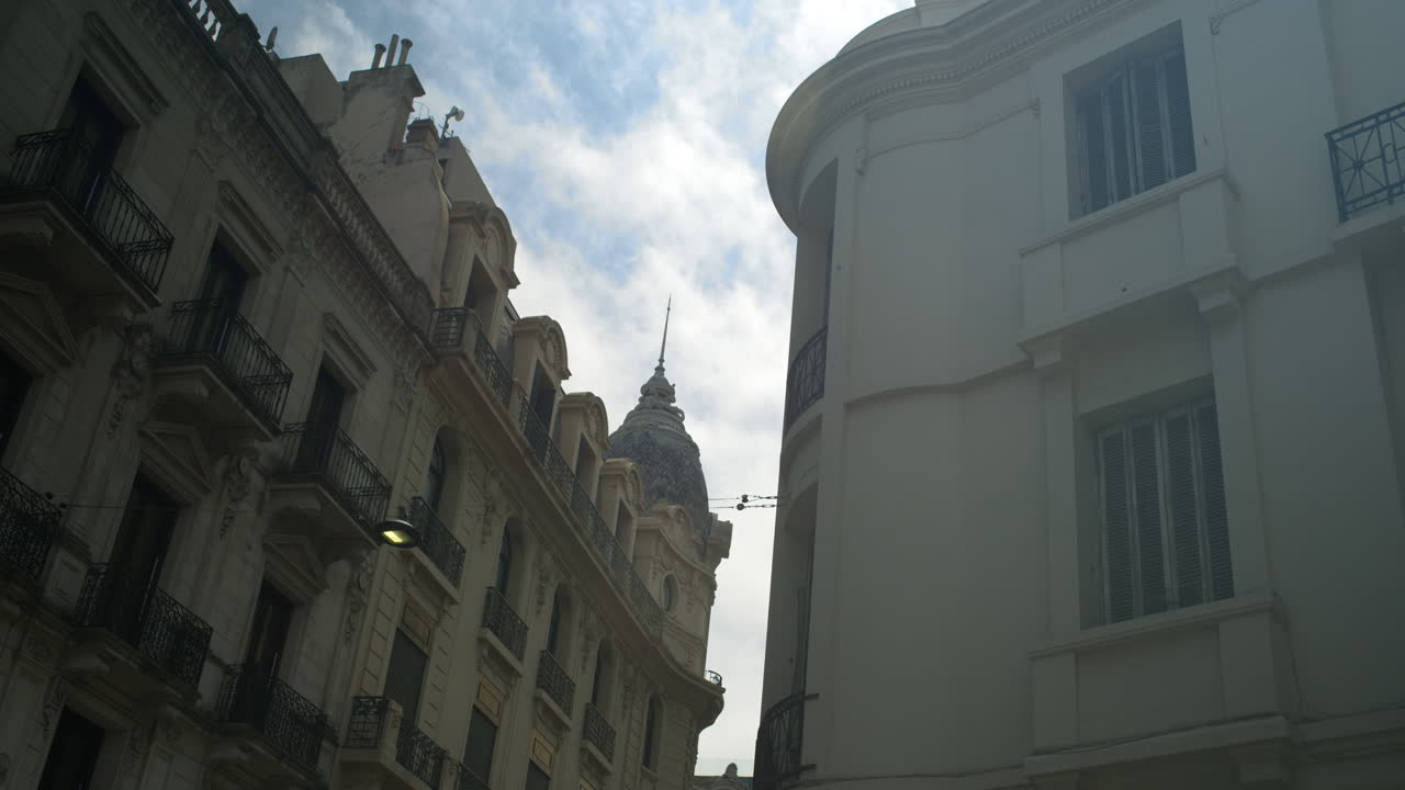 Veduta dal basso di vecchi edifici cittadini contro un cielo nuvoloso