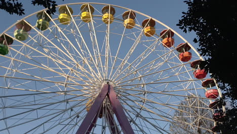 tilt down of colorful ferris wheel stopped at amusement park