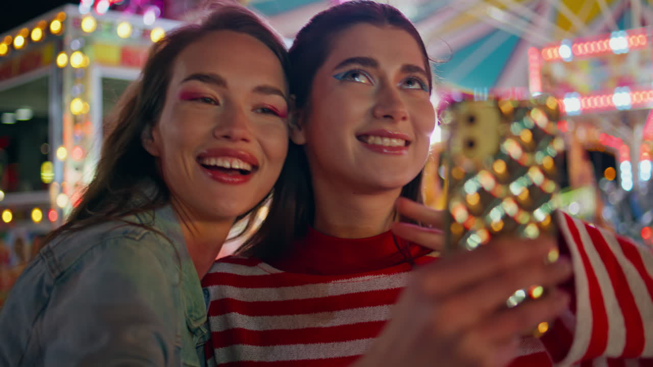재미있는 친구들이 휴대 전화 셀피 클로즈업. 즐거운 소녀들이 즐거운 밤을 보내고 있습니다.