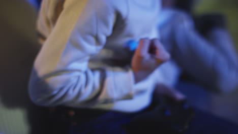 primer plano de un niño en casa celebrando jugando con la consola de juegos de computadora en la televisión sosteniendo controladores tarde en la noche