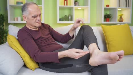 The-old-man-with-cracks-in-his-heels.-He-is-applying-cream-with-her-hand.