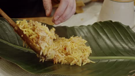 laying out biriyani rice onto a palm tree leave